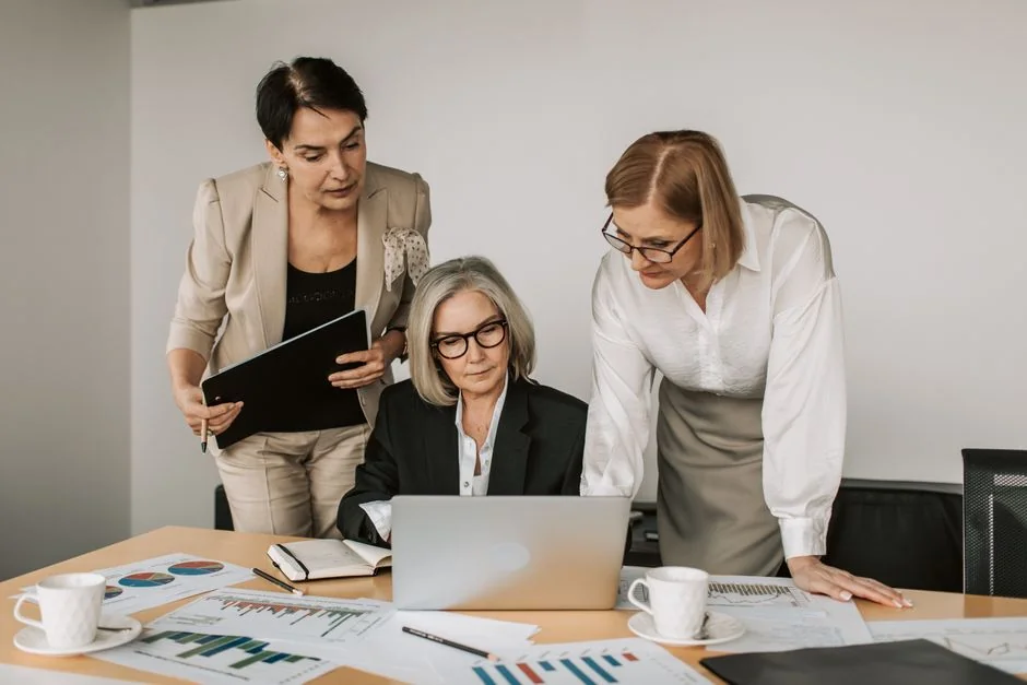 Une équipe variée travaillant ensemble sur des stratégies de marketing digital autour d’une table, avec des ordinateurs portables et des tablettes.